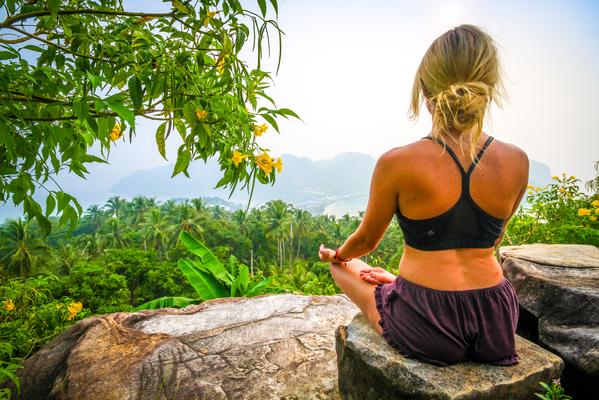 Meditating female sitting cross-legged on a rock