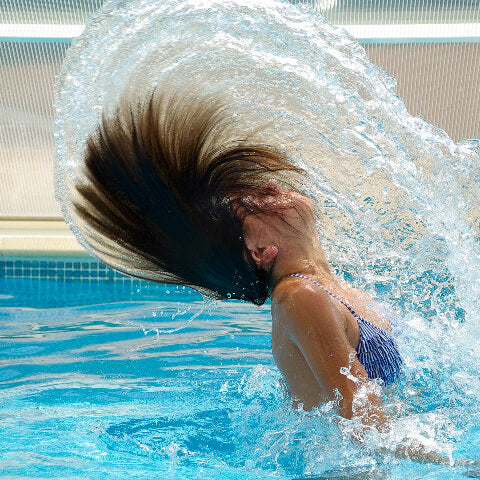Woman playing with hair in water