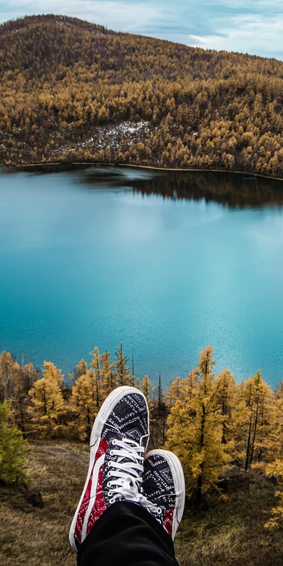 Human sitting with just feet showing overlooking a lake