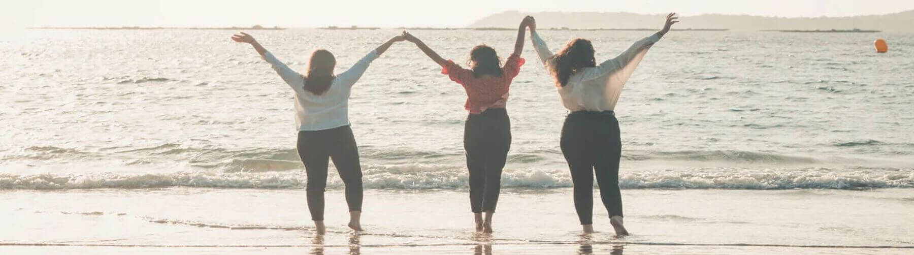 Three ladies on a beach celebrating